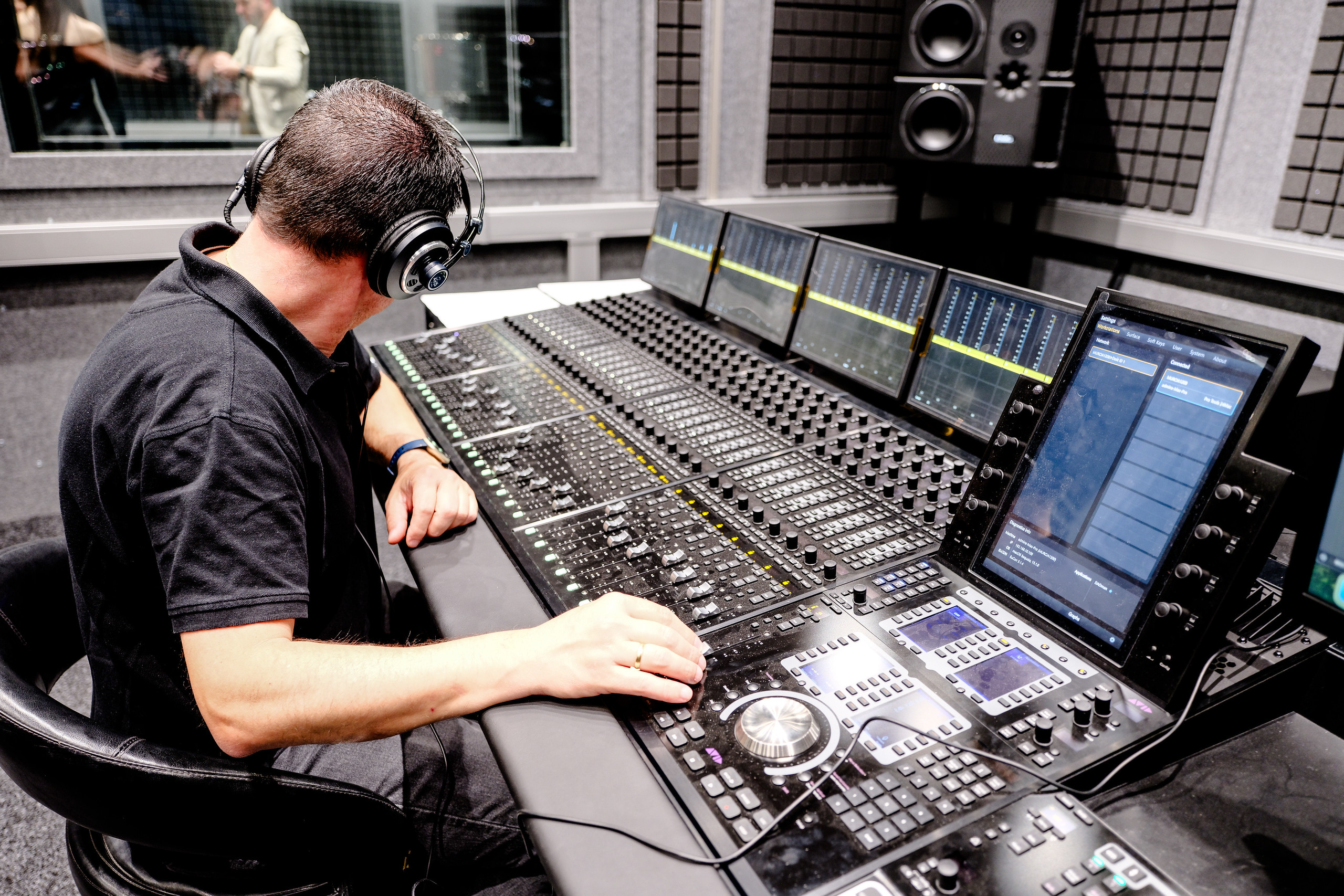 Técnico con auriculares trabajando en una mesa de mezclas del Hub